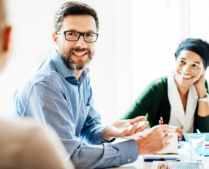 employees at a table discussing payer provider partnerships
