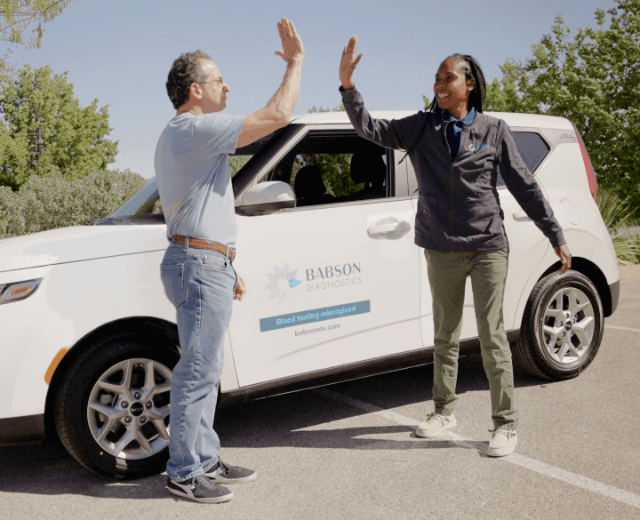 two babson employees outside high fiving
