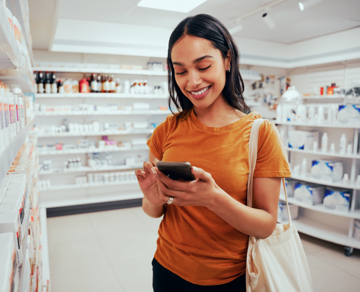 young lady at a pharmacy smiling while on her phone